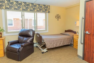 Private resident room with a bed and reclining chair