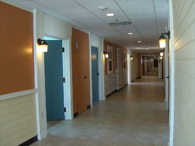 Hallway with orange and blue doors in a facility