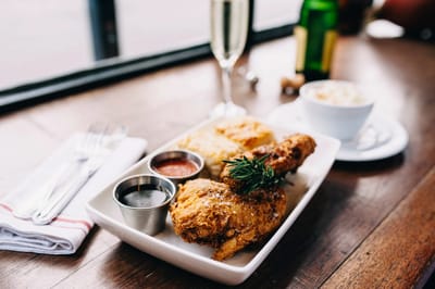 A plate of fried chicken with sides on a table