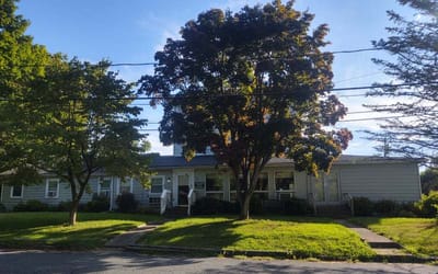 Exterior view of Clover Rest Home with trees
