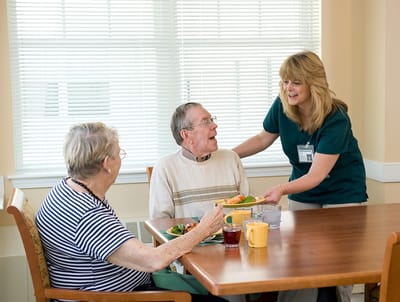 Staff serving food to residents in the dining room