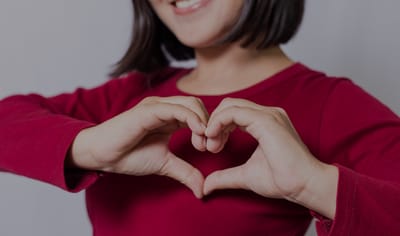 Person forming a heart shape with hands