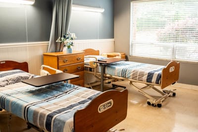 A shared resident room with two beds and natural light