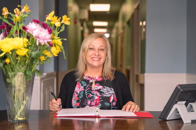 Staff member at a reception desk in a facility lobby