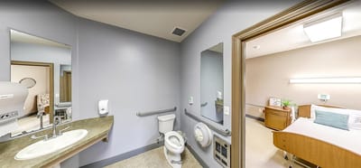 A well-lit resident room with bathroom facilities