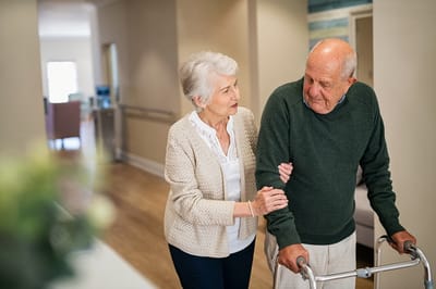 A staff member assisting a resident in a corridor
