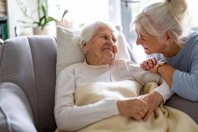 A caregiver interacting with a senior resident in a cozy setting