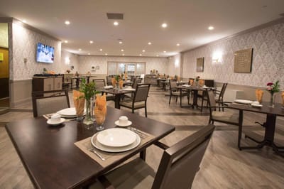 Dining room set up for a meal with tables and chairs