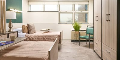 A comfortable shared resident room with beds and seating