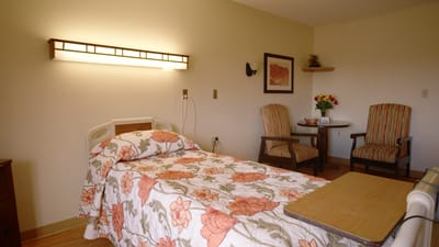 Cozy resident room with floral bedding and seating area