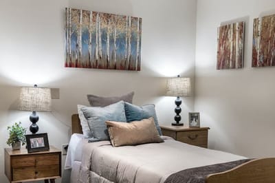 A well-decorated private resident room with a bed