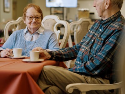 Two residents enjoying coffee together at a table
