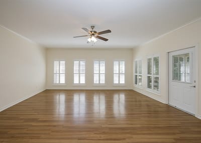 Bright common area with wooden floor and ceiling fan