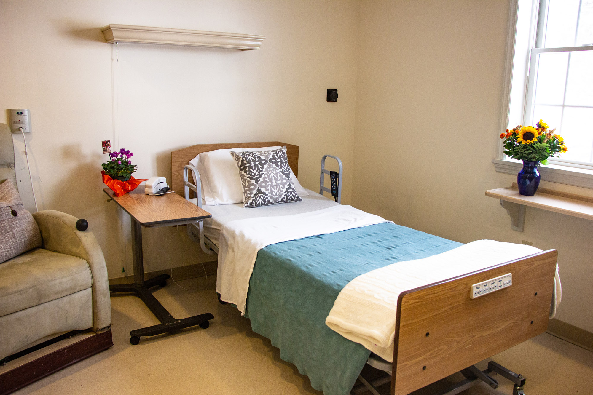 Interior view of a resident's room with a bed and flowers