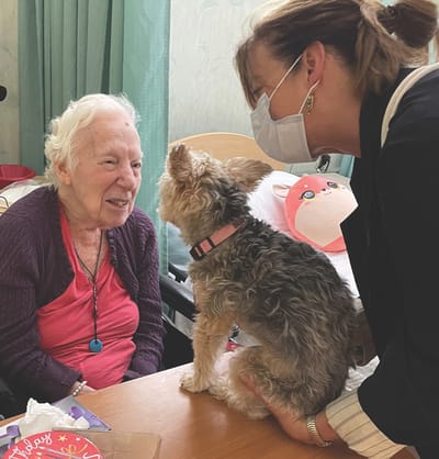 Staff member interacting with a resident and a dog