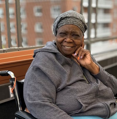 Resident smiling while seated on a patio