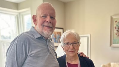 Two residents posing together in a cozy room