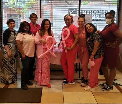 Staff members in pink attire for a celebration event