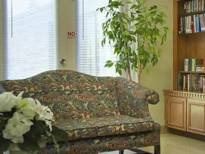 Cozy common area with floral couch and bookshelf