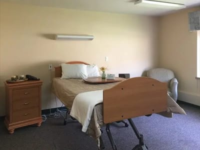 A private resident room with a bed and chair