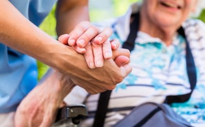 Avamere Rehabilitation of Clackamas, nursing home in Gladstone, OR — Caring hands assisting an elderly resident in a wheelchair