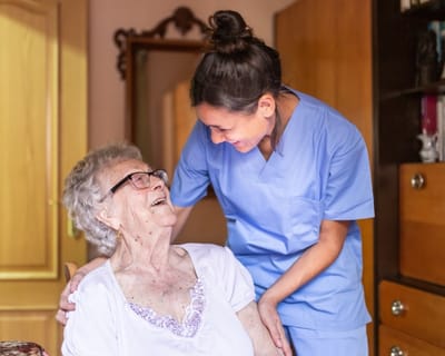 Avamere Rehabilitation of Clackamas, nursing home in Gladstone, OR — Caregiver interacting with a smiling elderly resident