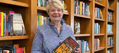 Resident holding a book in a library area