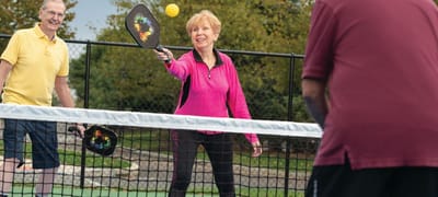 Residents playing pickleball outdoors