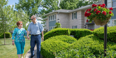 Residents walking in the garden area of the facility