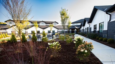 Aspen Transitional Rehab, Nursing Home in Meridian, ID — landscaped garden with seating area and buildings in background