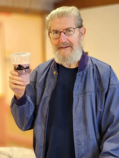 Resident enjoying a smoothie in a facility common area