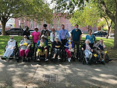 Residents and staff posing outdoors in the garden