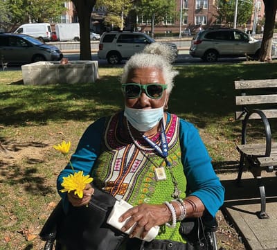 Senior resident enjoying the outdoors with a flower