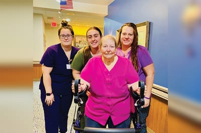 Staff assisting a resident in a hallway