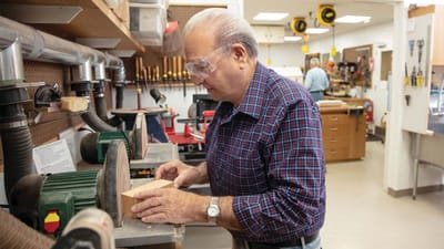 Resident woodworking in a workshop area