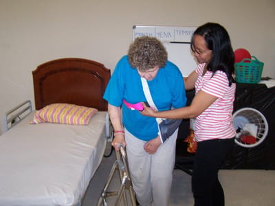 Staff assisting a resident in an interior setting