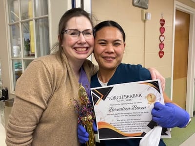 Staff member celebrating with a resident in a cheerful environment
