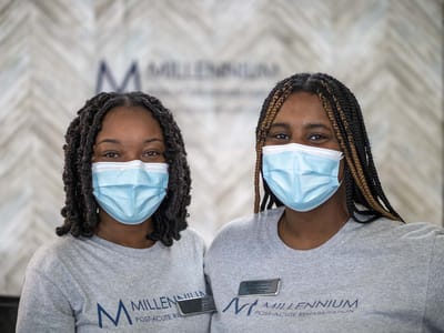 Two staff members in Millennium Post Acute Rehabilitation uniforms