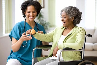 Caregiver assisting a resident with exercise in a bright room