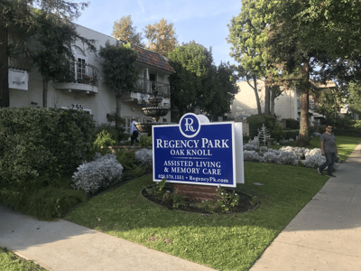 Exterior view of Regency Park Oak Knoll with residents walking by