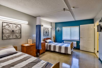 A shared resident room with two beds and decor