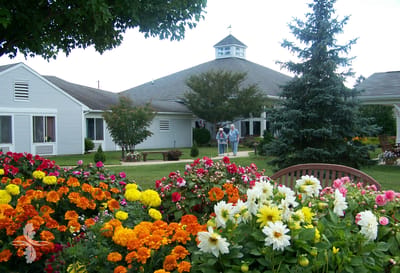 Residents walking in a flower-filled garden outside the facility