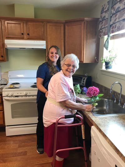 Staff assisting a resident in a kitchen