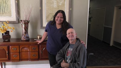 Staff member and resident smiling in a common area