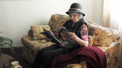 Resident reading a magazine in a cozy lounge area