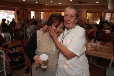 Two residents sharing a joyful moment in a common area