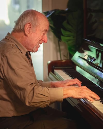 Senior man playing piano in a warm indoor setting