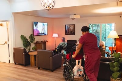 Residents relaxing in a common area with a television.