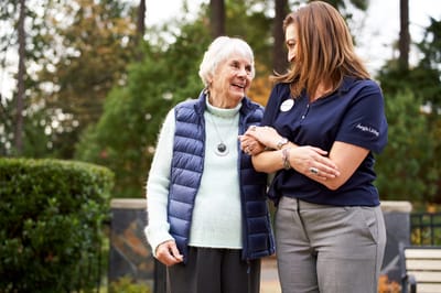 Staff member interacting with a senior resident outdoors