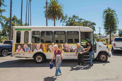Residents boarding a facility shuttle bus outside
